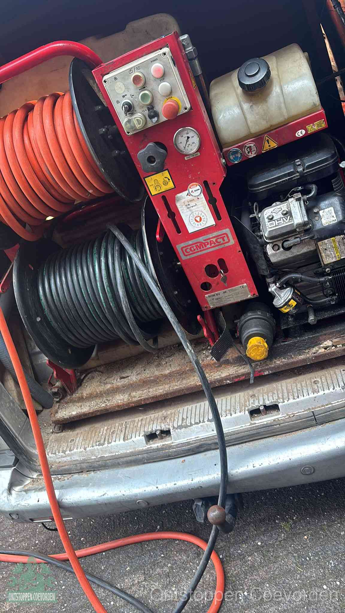 Een rood hogedruk-rioolreinigingstoestel in de laadbak van de bedrijfsbus, apparatuur voor een hardnekkige afvoerverstopping in Coevorden