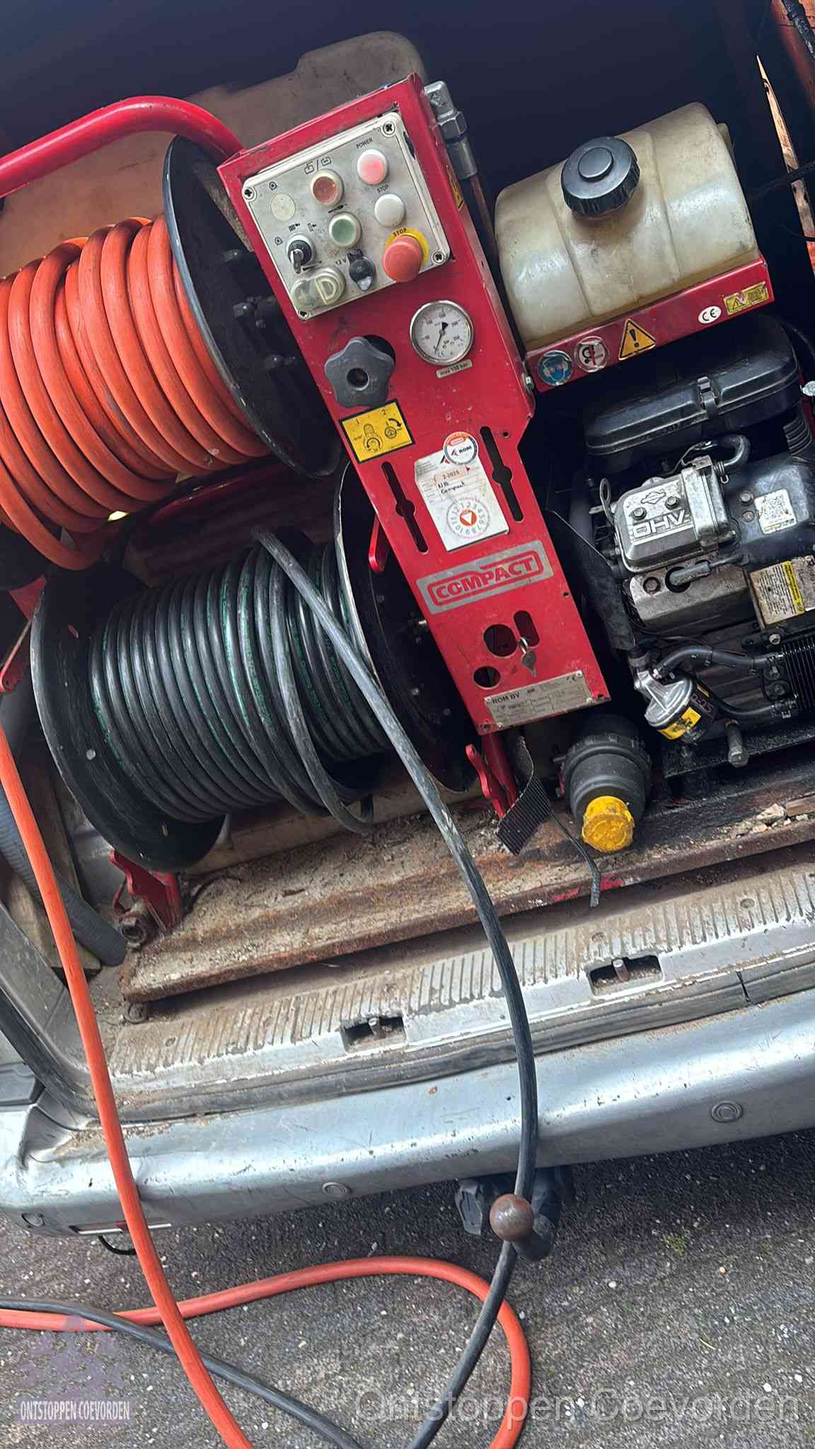 Een rood hogedruk-rioolreinigingstoestel met slangen in de laadbak van de bedrijfsbus, apparatuur voor een hardnekkige wc-verstopping in Coevorden